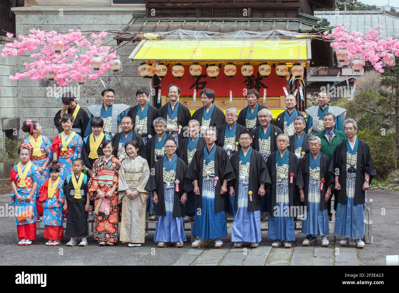 Die Leute von Nikko stehen vor einem Festwagen (hanayatai) für ein formelles Gruppenfoto an, bevor sie am jährlichen Yayoi Matsuri Spring Festival in Japan teilnehmen Stockfoto