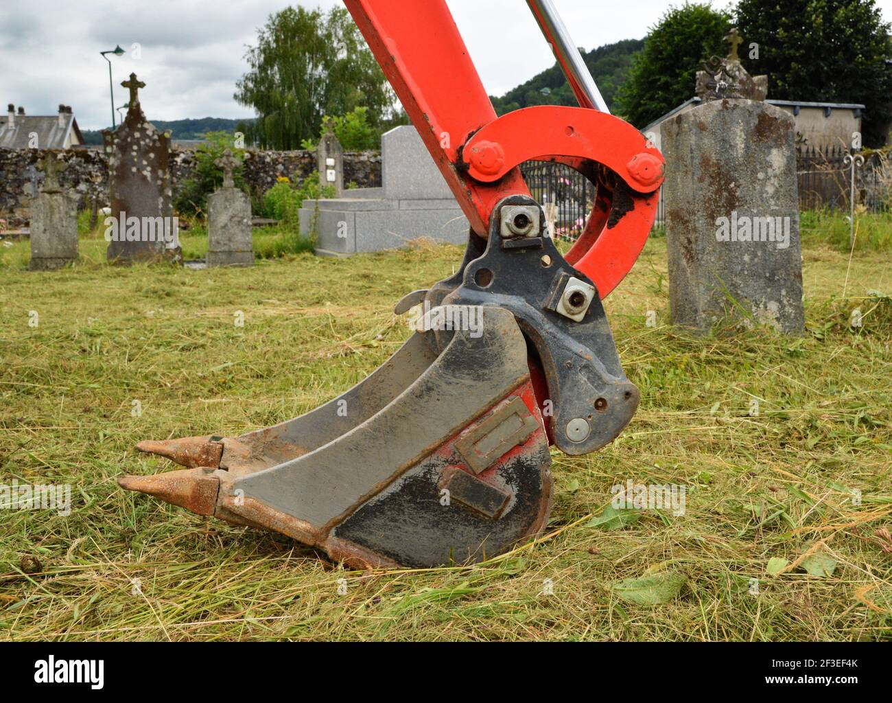 Ein Bagger zum Graben eines Grabes auf einem Friedhof zur Begräbnis oder Exhumierung. Stockfoto