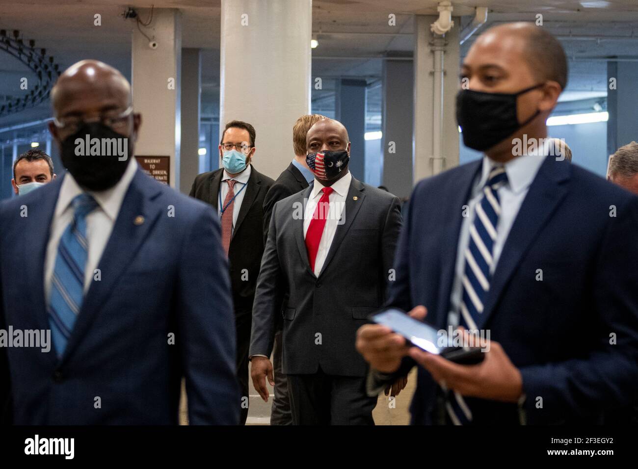 Die Vereinigten Staaten Senator Raphael G. Warnock (Demokrat von Georgia), links, und die Vereinigten Staaten Senator Tim Scott (Republikaner von South Carolina), Mitte, machen ihren Weg durch die Senat U-Bahn für eine Abstimmung im US-Capitol in Washington, DC, Dienstag, 16. März 2021. Kredit: Rod Lampey/CNP /MediaPunch Stockfoto