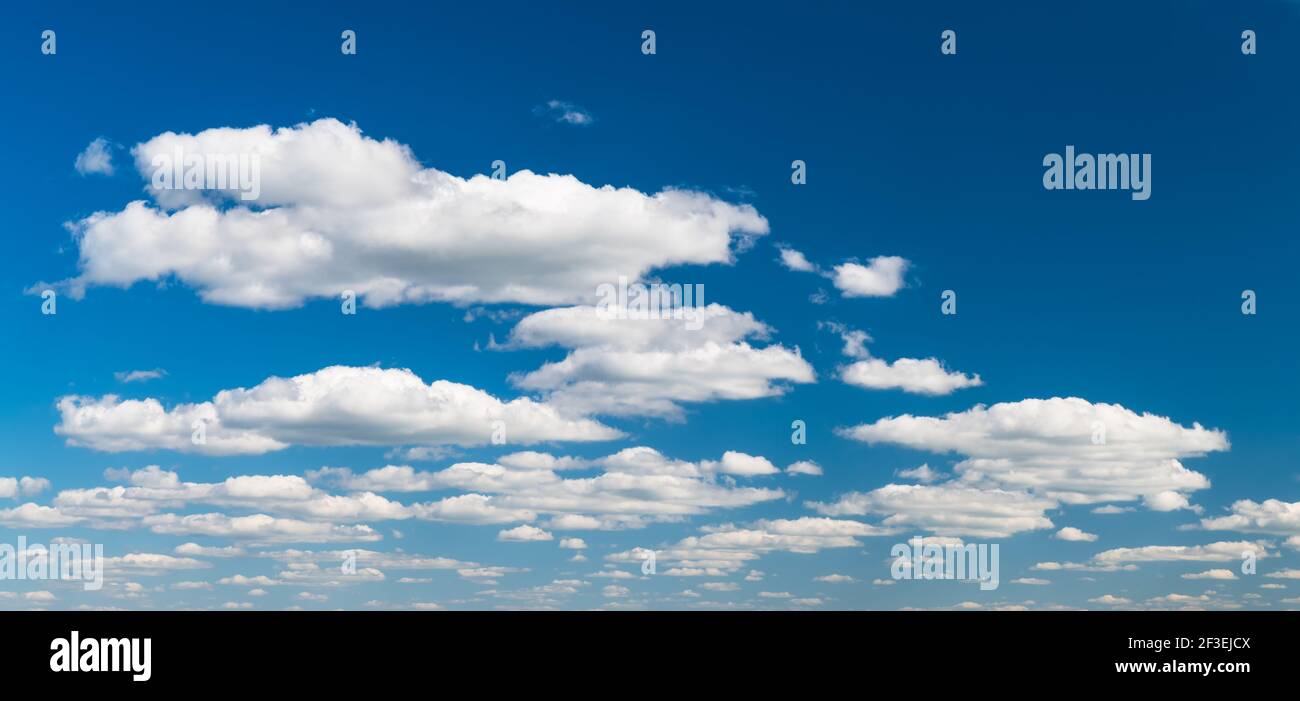 Gruppe von idyllischen schwebenden weißen Wolken auf azurblauem Himmel Hintergrund. Ruhige natürliche Panorama Wolkenlandschaft Szene. Umwelt, Wetter oder Meteorologie. Stockfoto
