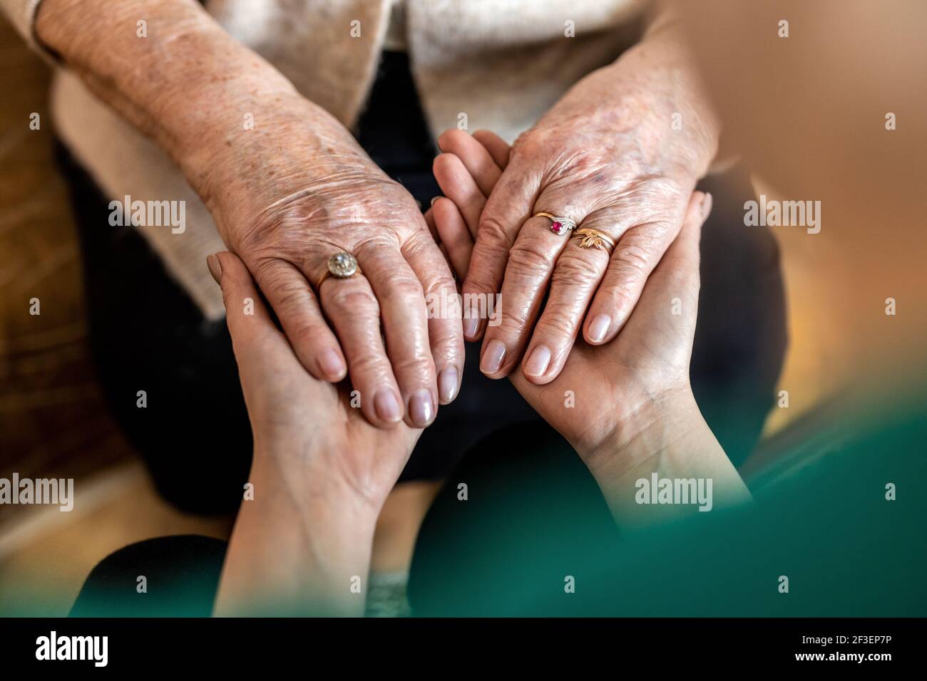 Zugeschnittenes Bild einer älteren Frau, die die Hände mit einem hält Krankenschwester Stockfoto