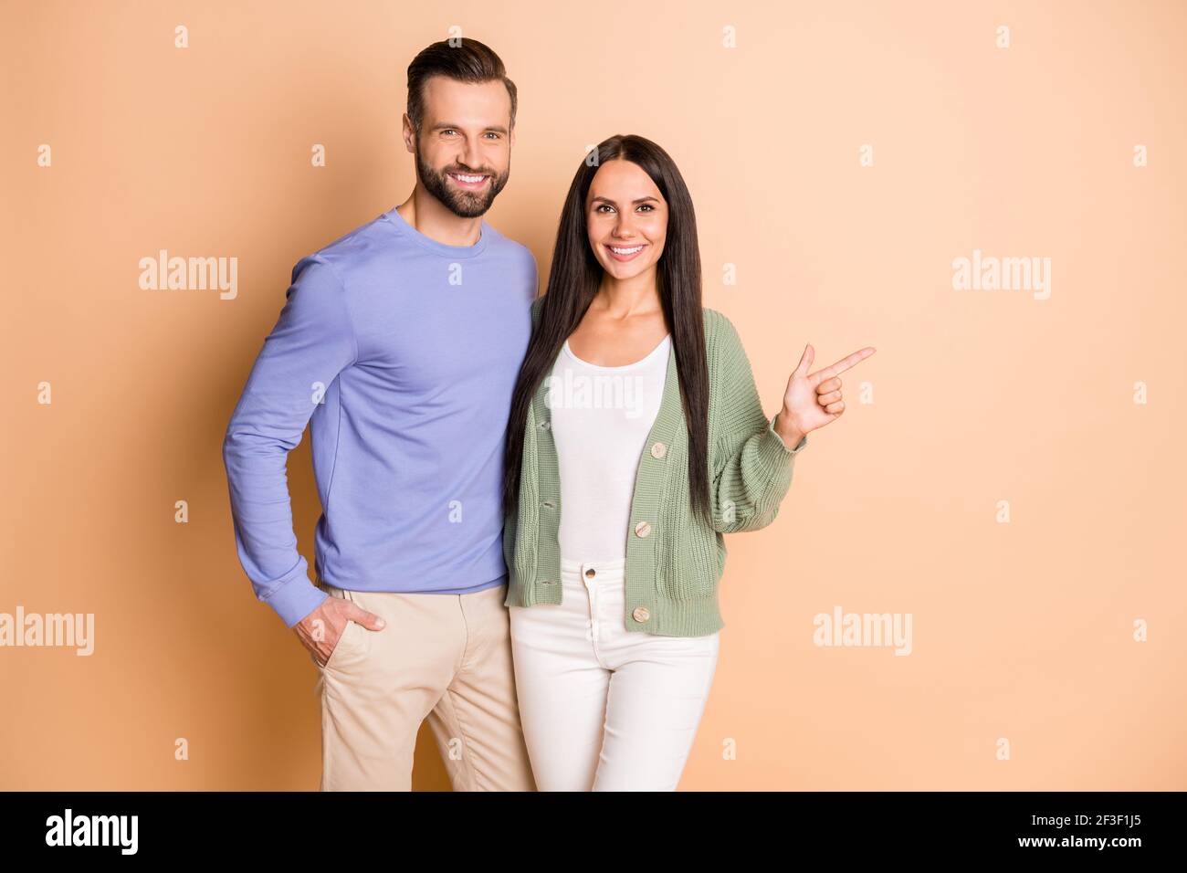 Foto von jungen glücklich lächelnd positive fröhliche Paar Frau Punkte Finger Copyspace isoliert auf beigefarbenem Hintergrund Stockfoto