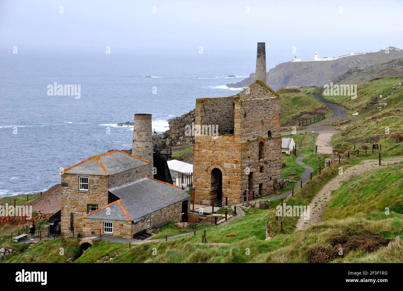 Levant Zinnmine mit seiner dampfbetriebenen Strahlmaschine auf der Klippe bei Penwith, auf der Landzunge dahinter ist der Pendeen Leuchtturm. Cornwall, England, Großbritannien Stockfoto