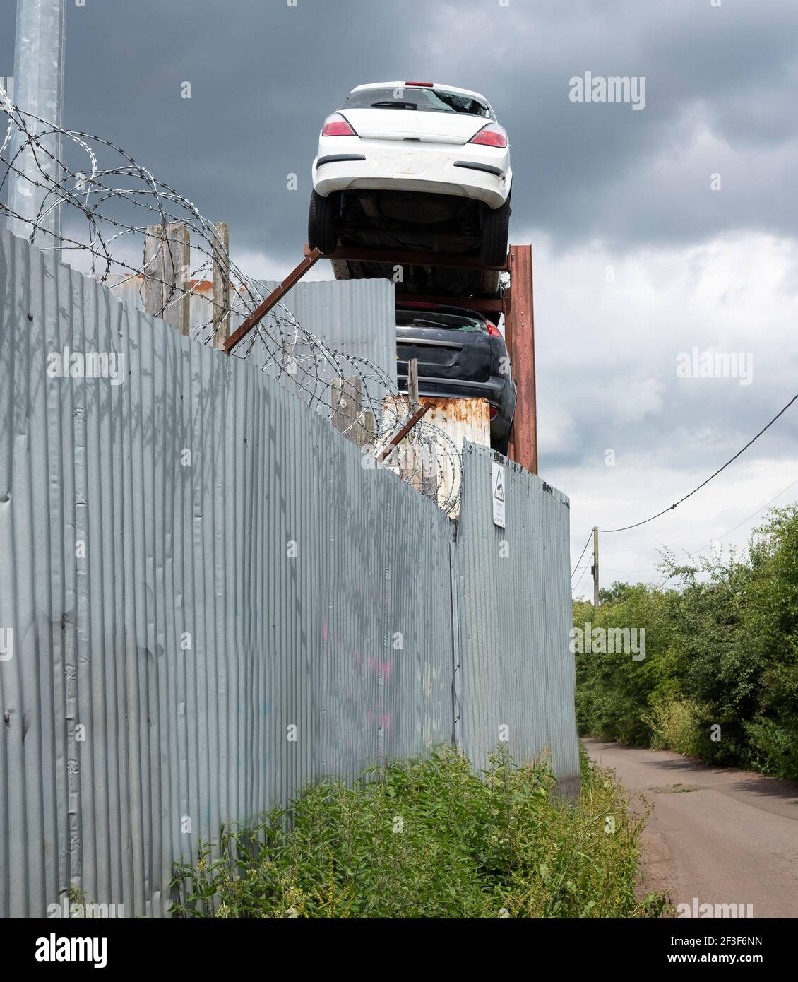 Altautos hoch oben hinter einem Zaun gelagert Stockfoto