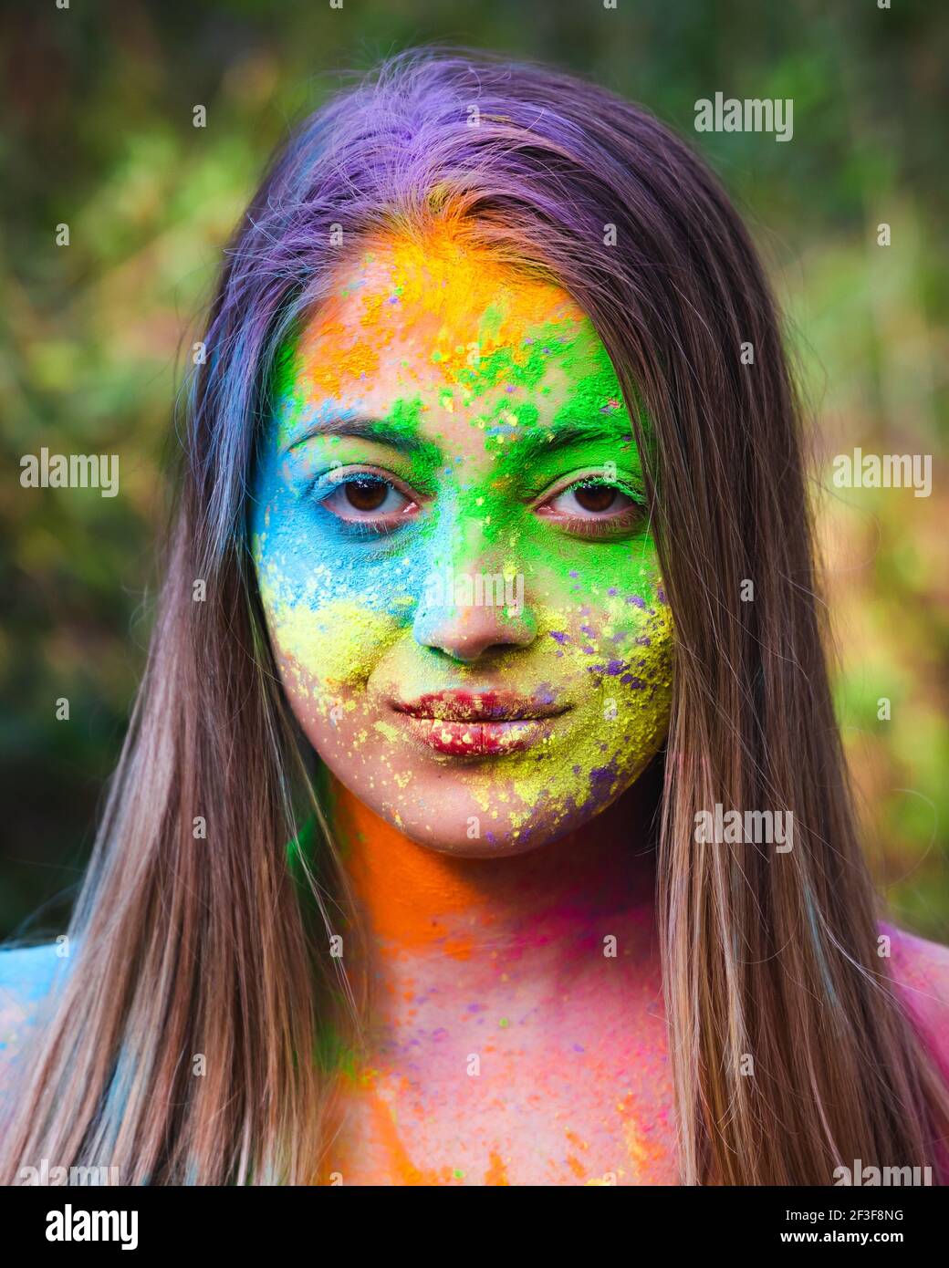 Wunderbare junge energetische Frau auf dem Holi Farbfestival der Farben im Park. Spaß im Freien. Bunte Puder färbt das Gesicht. Nahaufnahme. Stockfoto