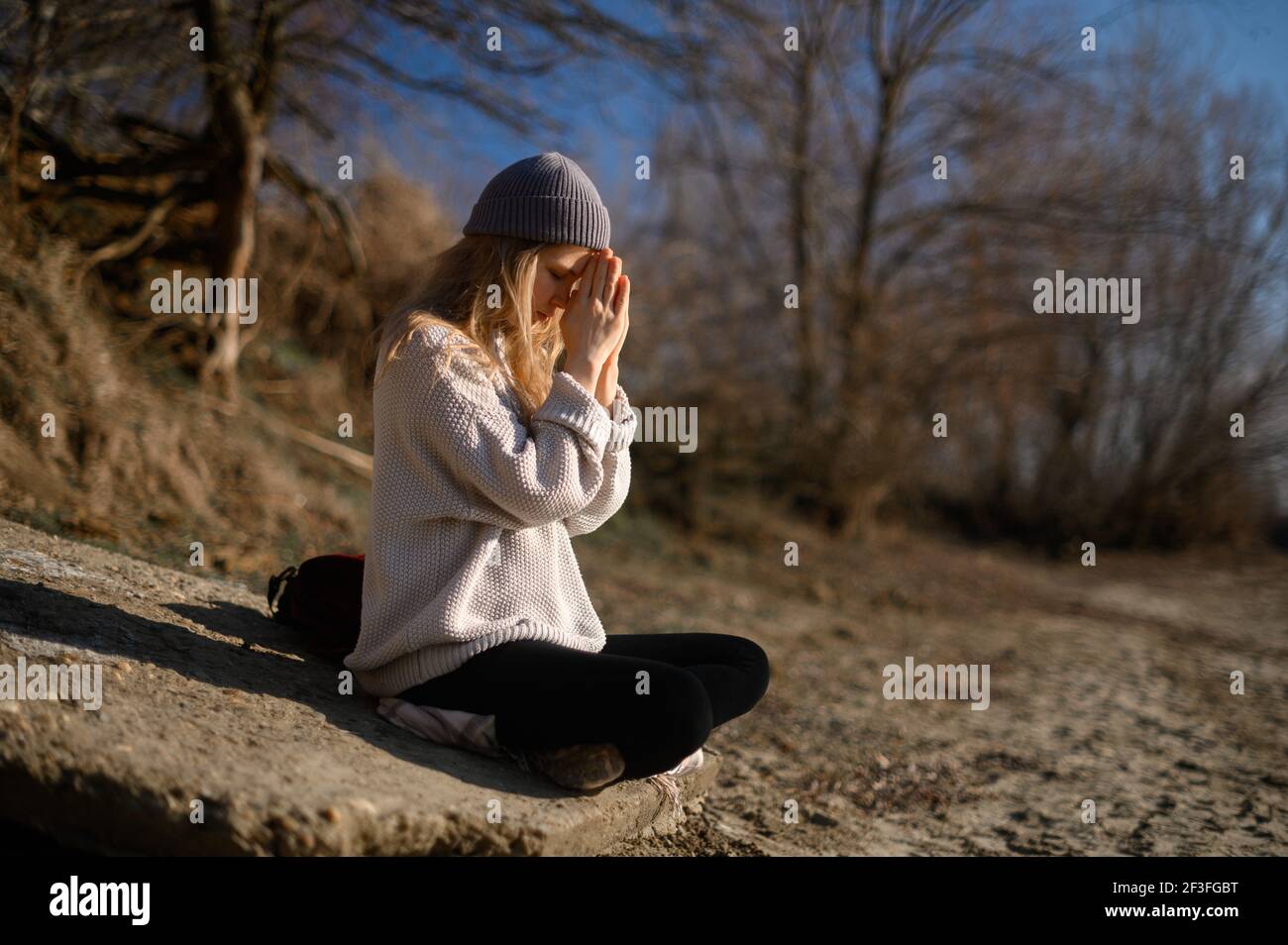 Praxis der Meditation und Interaktion mit der Natur. Mädchen in der Nähe des Flusses Stockfoto