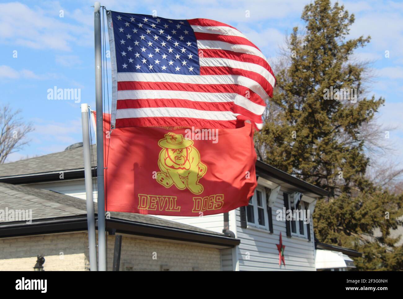 US Marine Corps Devil Dogs Flagge mit US Flagge oben Es an einem sonnigen Tag mit Cirrocumulus Wolken Stockfoto