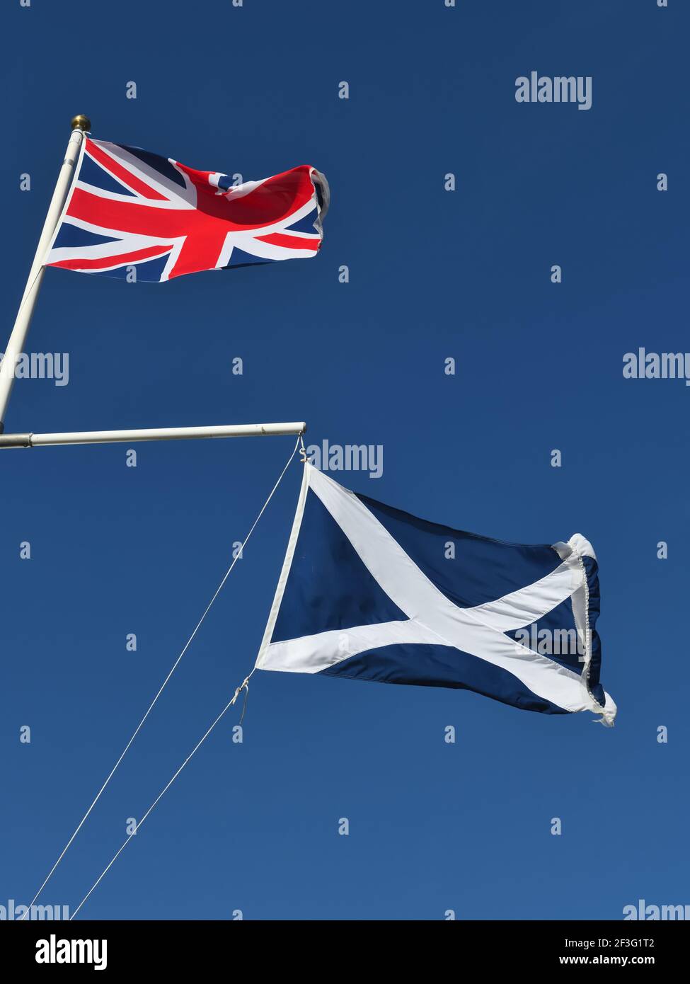 Die britische Flagge und der schottische Saltyre, St. Andrew's Cross, fliegen zusammen gegen einen blauen Himmel Stockfoto