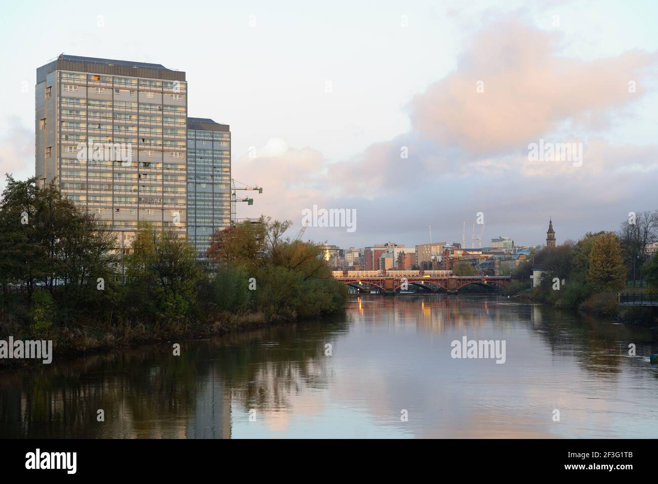 Hochhäuser mit Wohntürmen, die von der frühen Morgensonne am Fluss Clyde im Stadtzentrum von Glasgow, Schottland, Großbritannien, beleuchtet werden Stockfoto