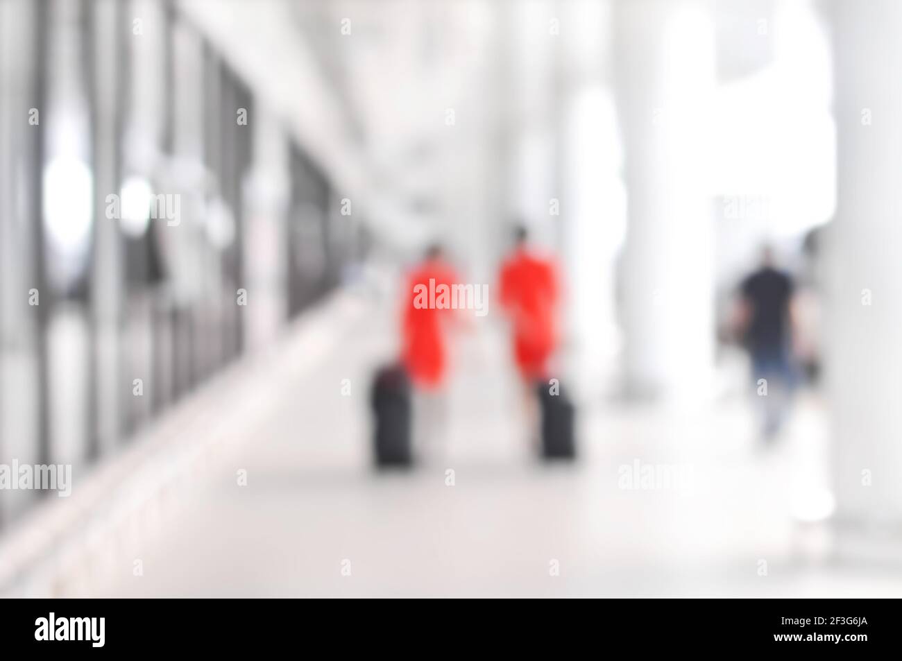 Verschwommene Leute und Flugbegleiter, die auf dem Flughafenflur herumlaufen Stockfoto