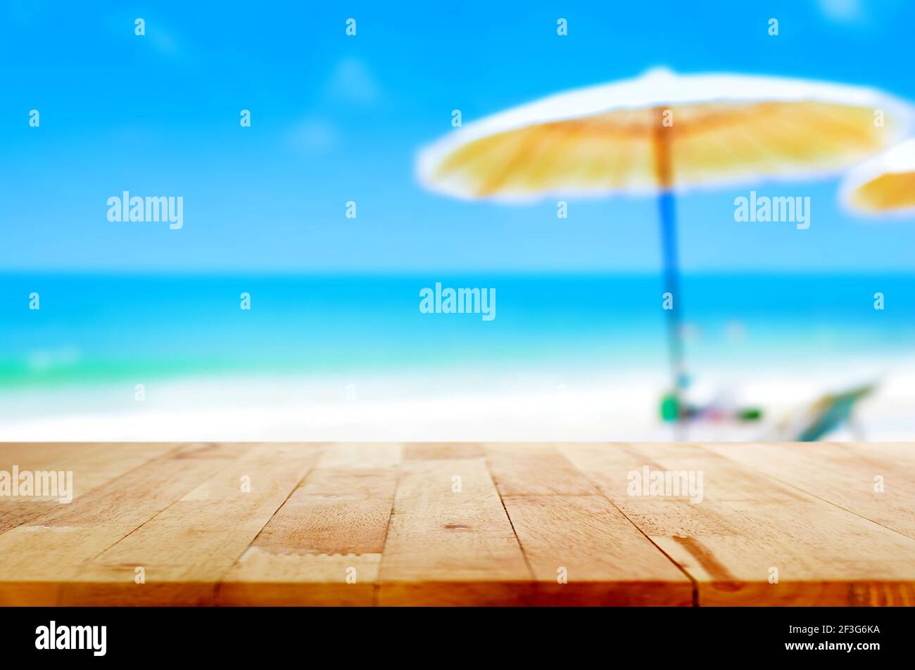 Holztischplatte auf verschwommenem blauem Meer und weißem Sand Strand Hintergrund - kann für Anzeige oder Montage verwendet werden Ihre Produkte Stockfoto
