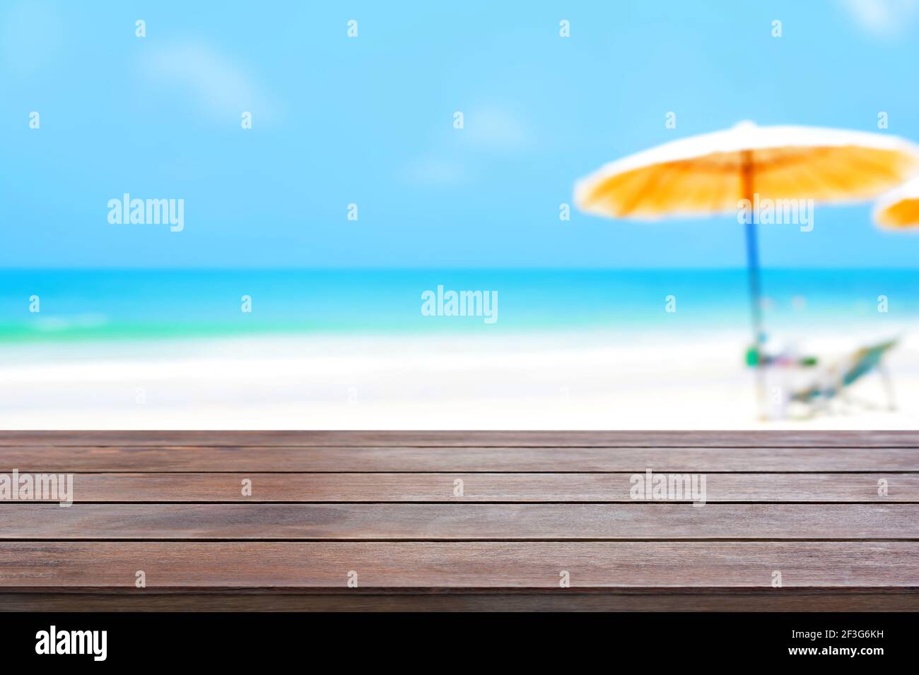 Alte dunkelbraune Holztischplatte auf verschwommenem Strand Hintergrund - kann zur Anzeige oder Montage Ihrer Produkte verwendet werden Stockfoto