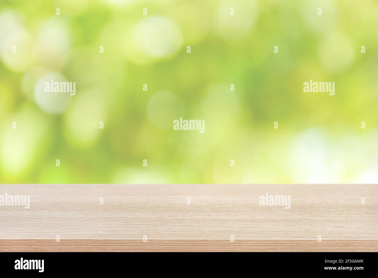 Holztischplatte auf grünem Bokeh abstrakter Hintergrund - Dose Für die Montage oder Anzeige Ihrer Produkte verwendet werden Stockfoto