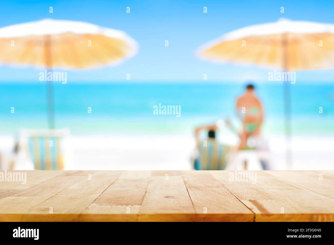 Holztischplatte auf verschwommenem schönen weißen Sand Strand Hintergrund Bei einigen Personen - kann für Montage oder verwendet werden Zeigen Sie Ihre Produkte an Stockfoto