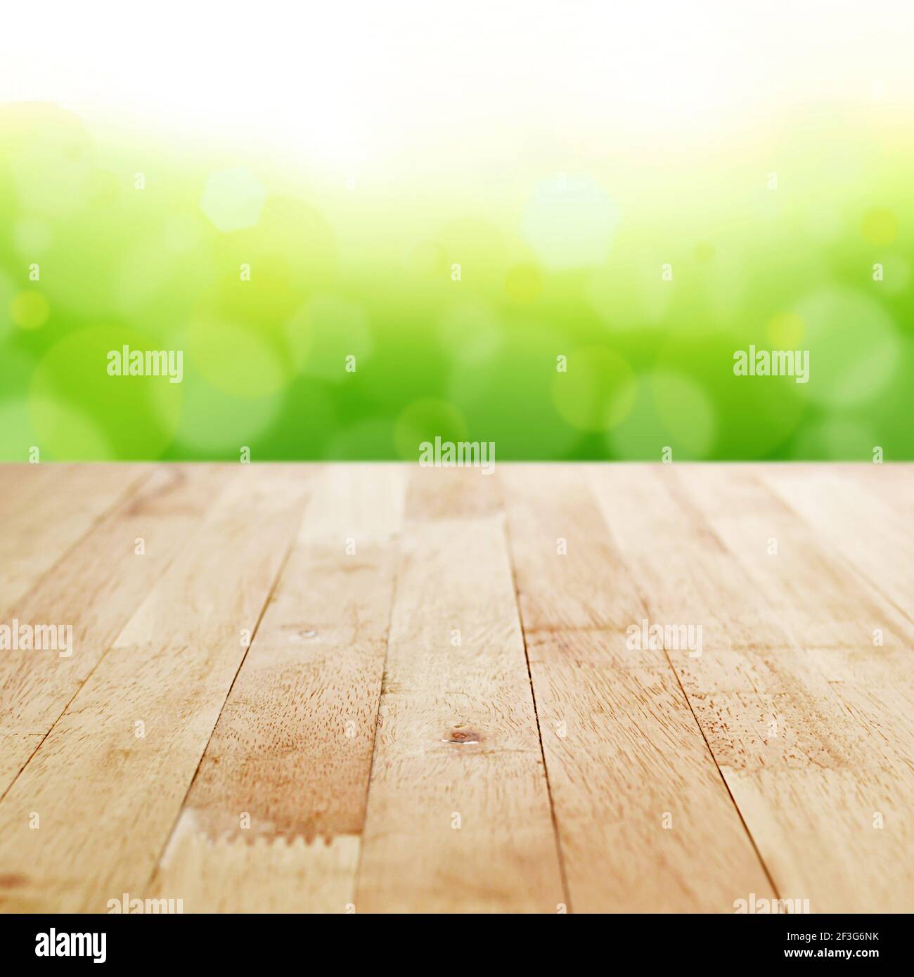 Holz Tischplatte auf Weichzeichnung grün Bokeh Hintergrund - kann Für die Montage oder Anzeige Ihrer Produkte verwendet werden Stockfoto
