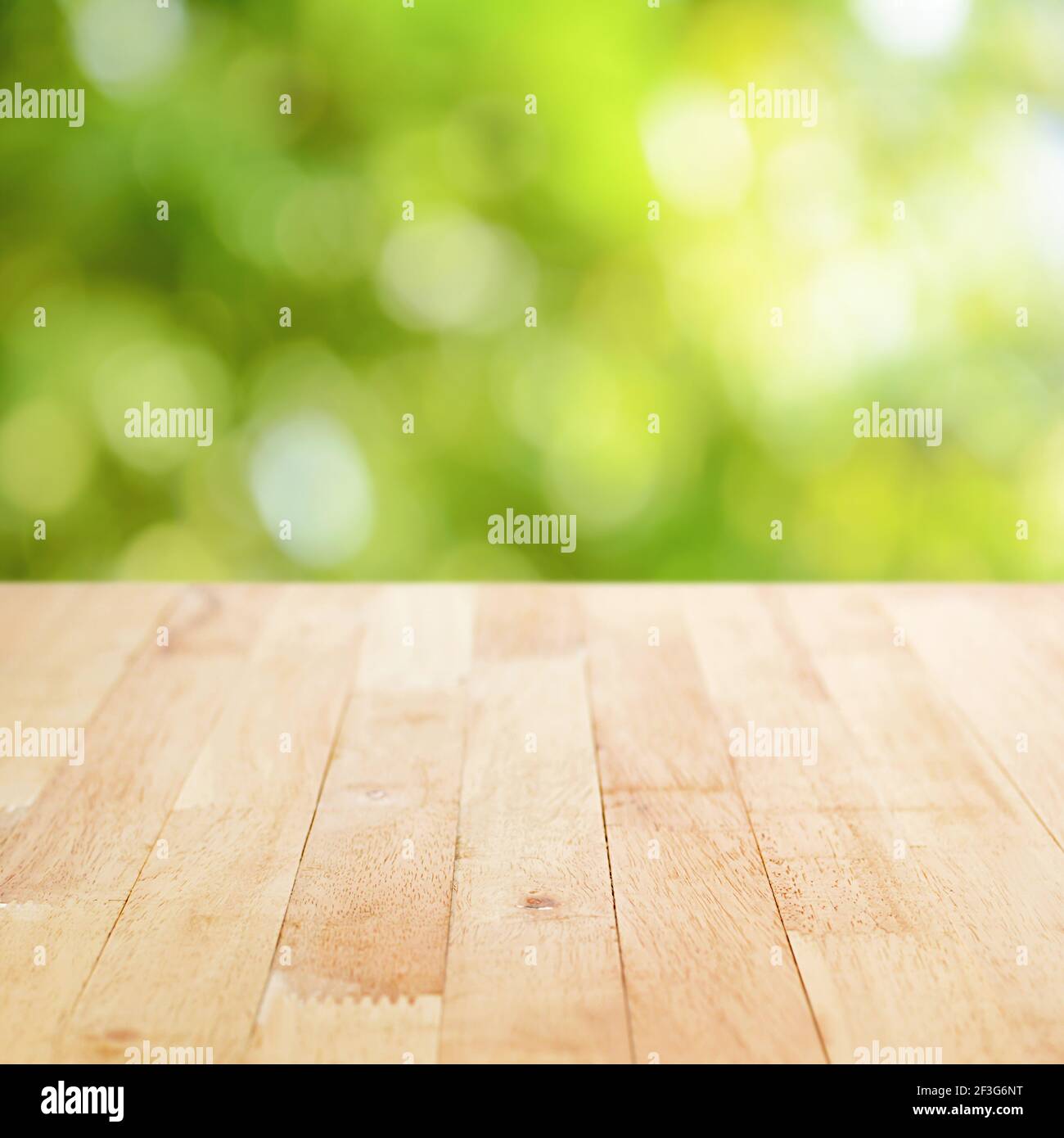 Holztischplatte auf grünem Bokeh abstrakter Hintergrund - Dose Für die Montage oder Anzeige Ihrer Produkte verwendet werden Stockfoto