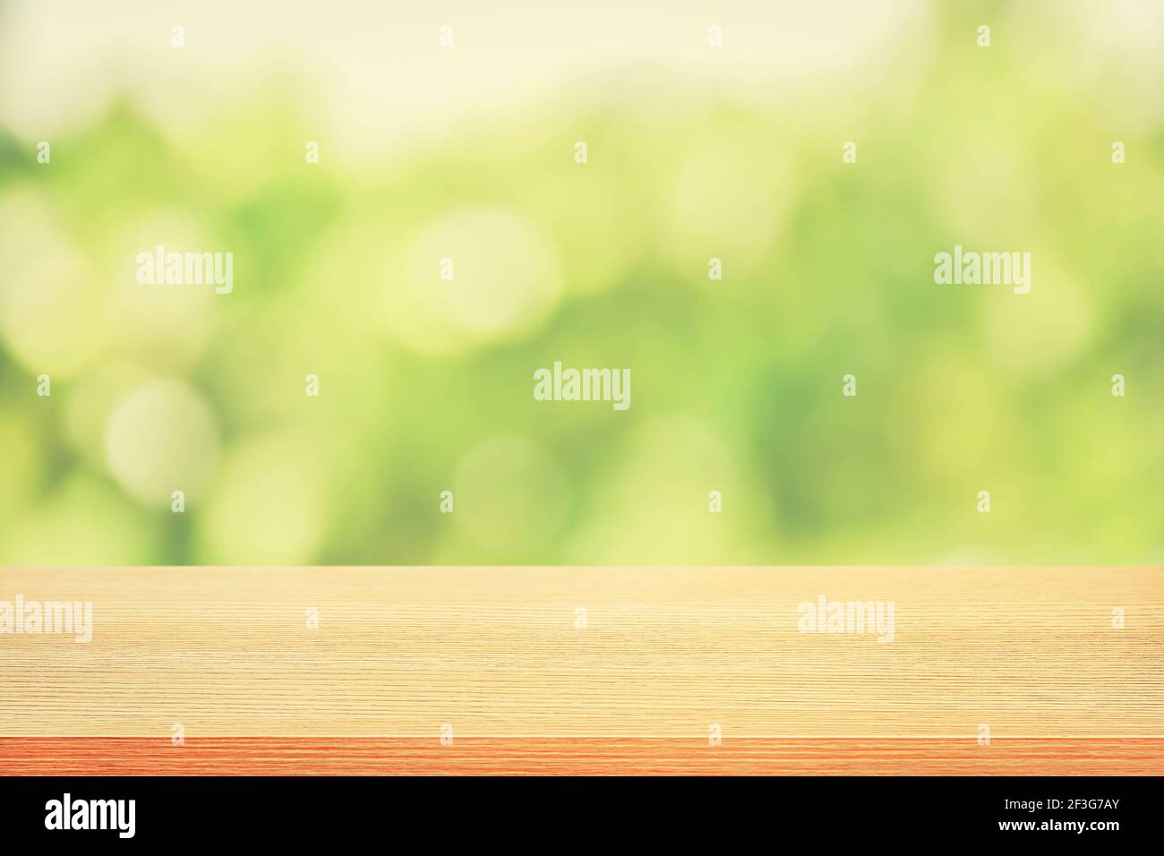 Holztischplatte auf grünem Bokeh abstrakter Hintergrund, weicher Ton - kann für Montage oder Anzeige Ihrer Produkte verwendet werden Stockfoto