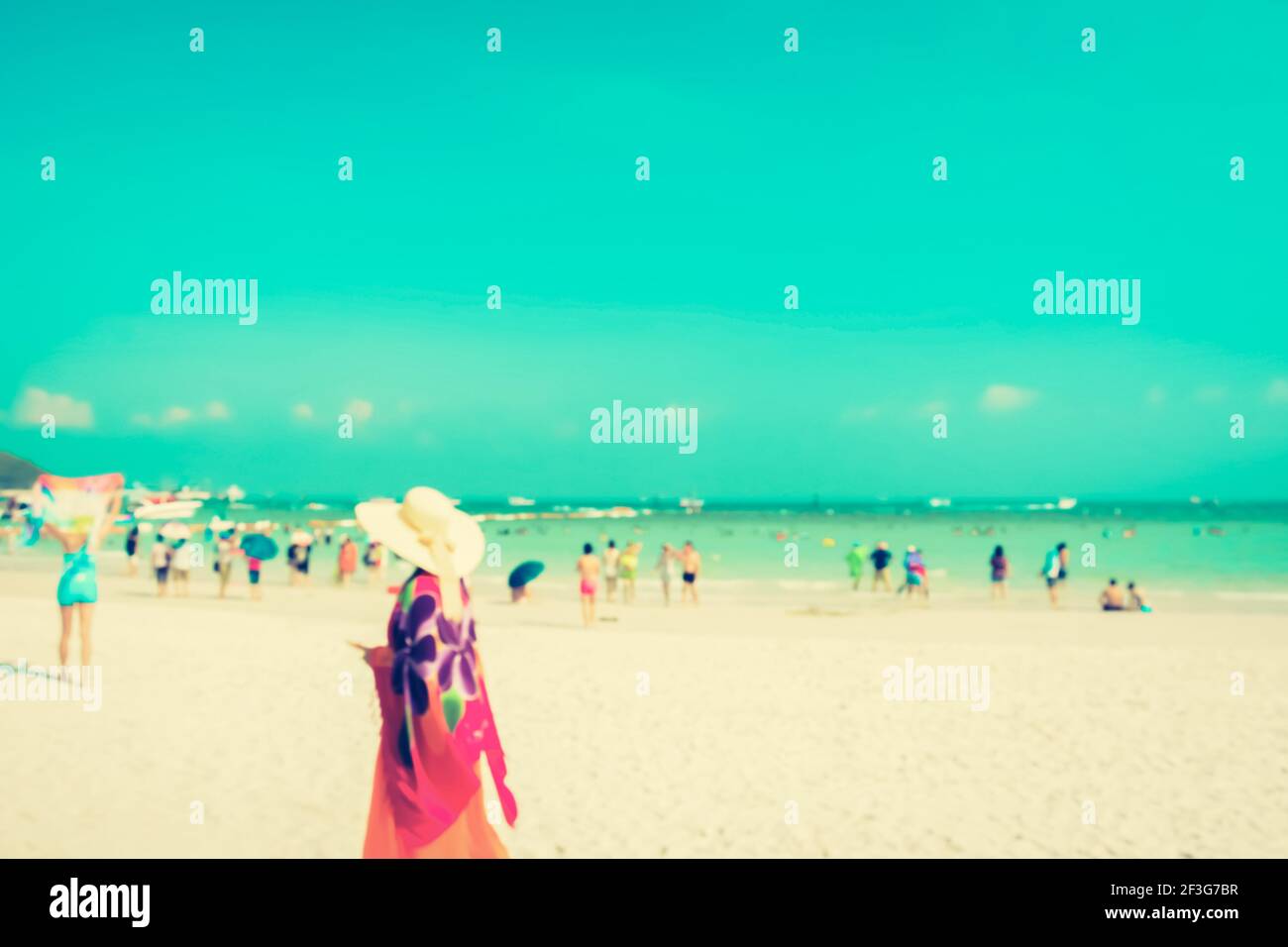 Verschwommene Menschen am weißen Sandstrand mit blauem Meer und Himmel Hintergrund - vintage Ton Stockfoto