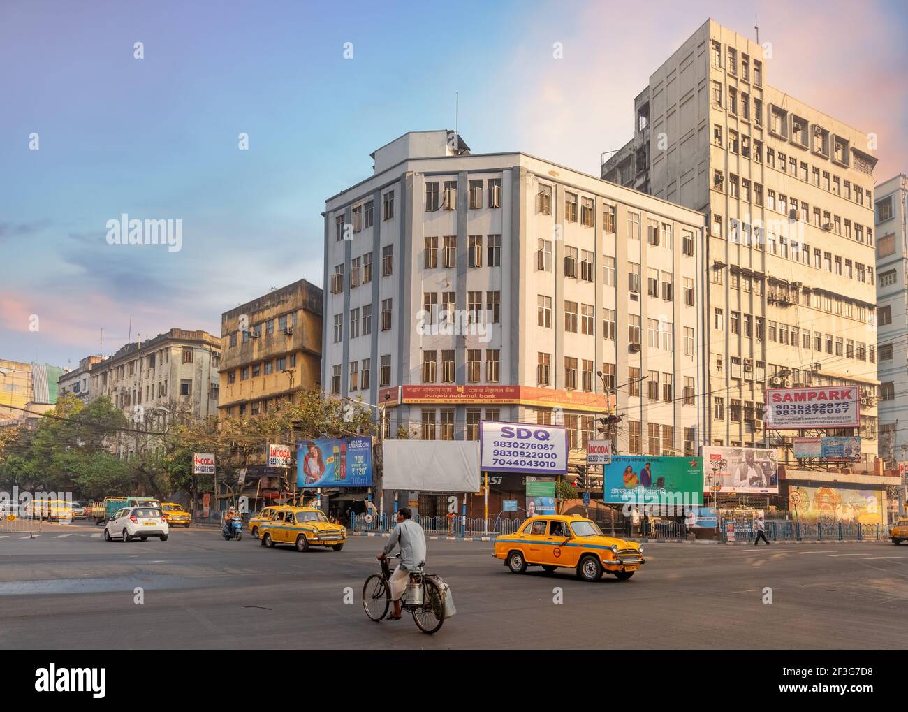 City Road Kreuzung mit öffentlichen Verkehrsmitteln Fahrzeuge und Blick auf Bürogebäude in Chandni Chowk Bereich von Kalkutta, Indien Stockfoto