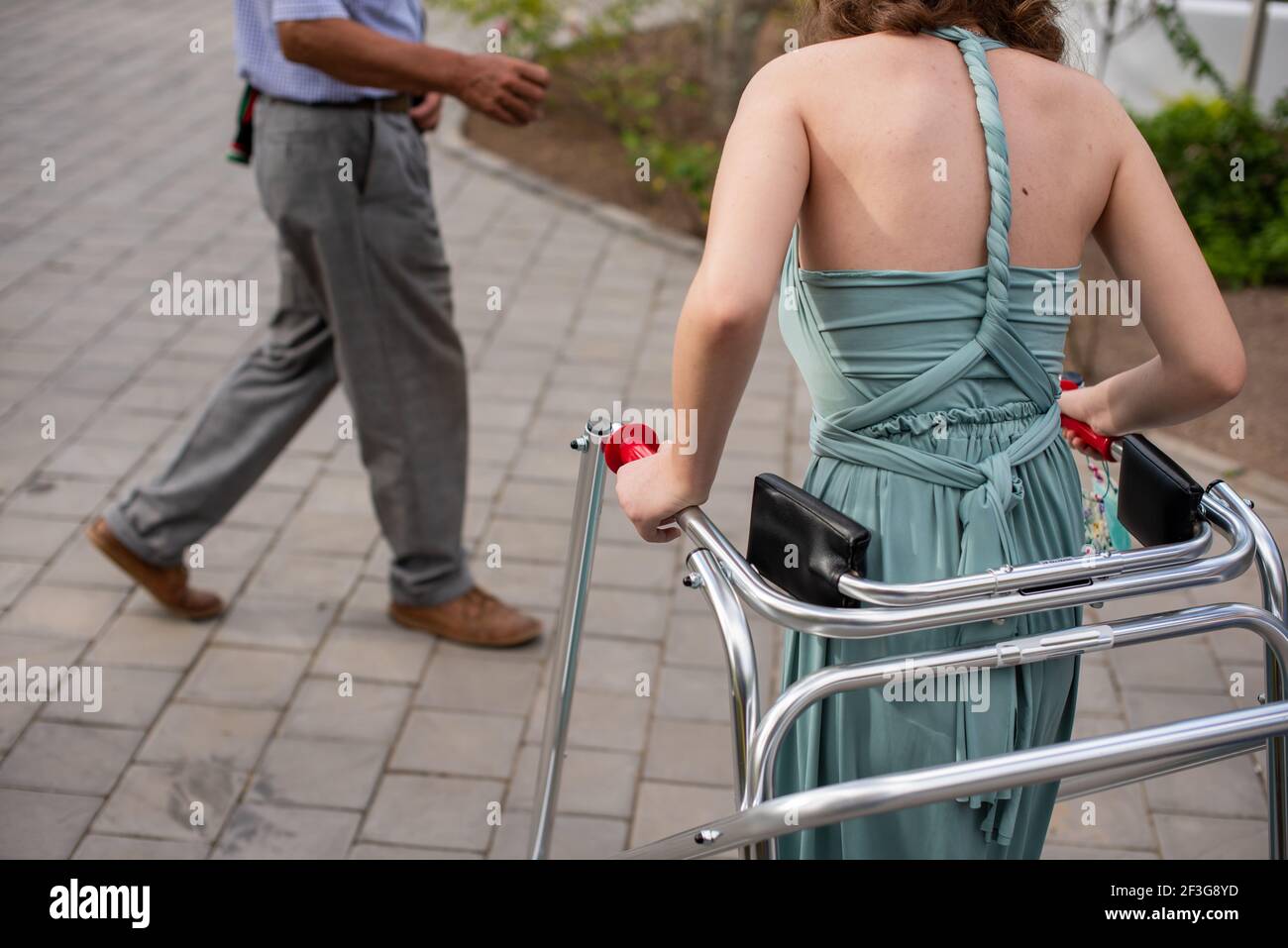 Behinderte junge Frau mit Gehhilfe im Freien Stockfoto