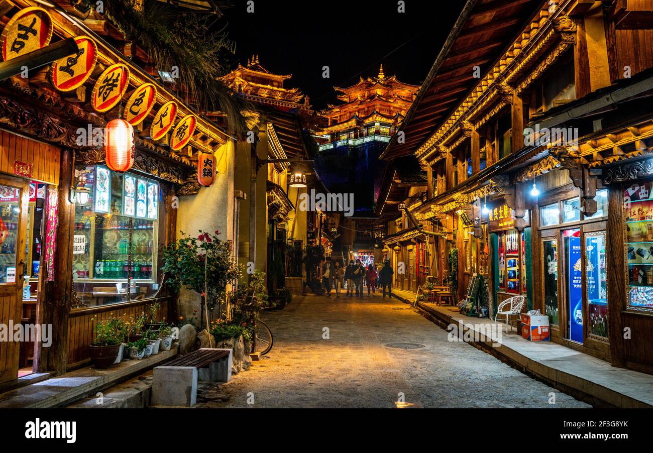 Shangrila , 8. Oktober 2020 : Dukezong Tibetische Altstadt szenische Straßenansicht mit Geschäften und Dafo Tempel beleuchtet in der Nacht im Hintergrund in Shangri-La Stockfoto