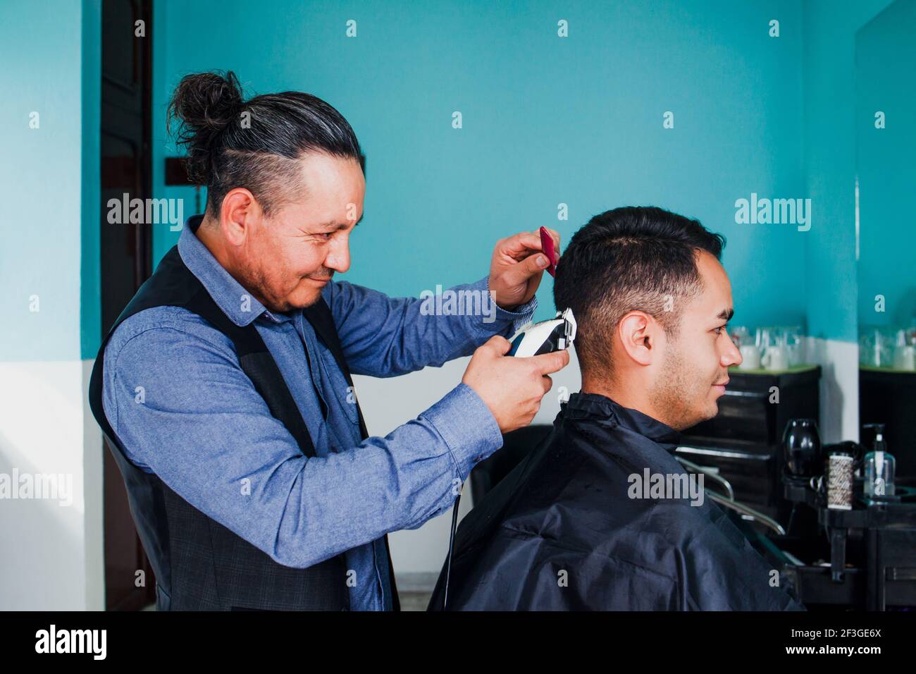 latein Mann Stylistin Schneiden Haare zu einem Kunden in ein Friseur in  Mexiko Stockfotografie - Alamy