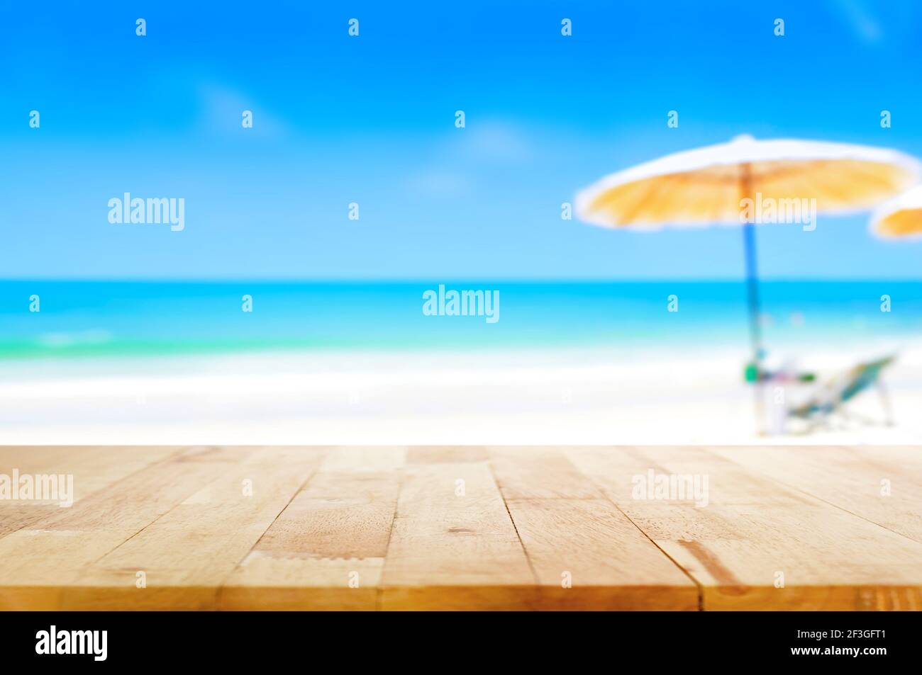 Holztischplatte auf verschwommenem blauem Meer und weißem Sand Strand Hintergrund - kann für Anzeige oder Montage verwendet werden Ihre Produkte Stockfoto