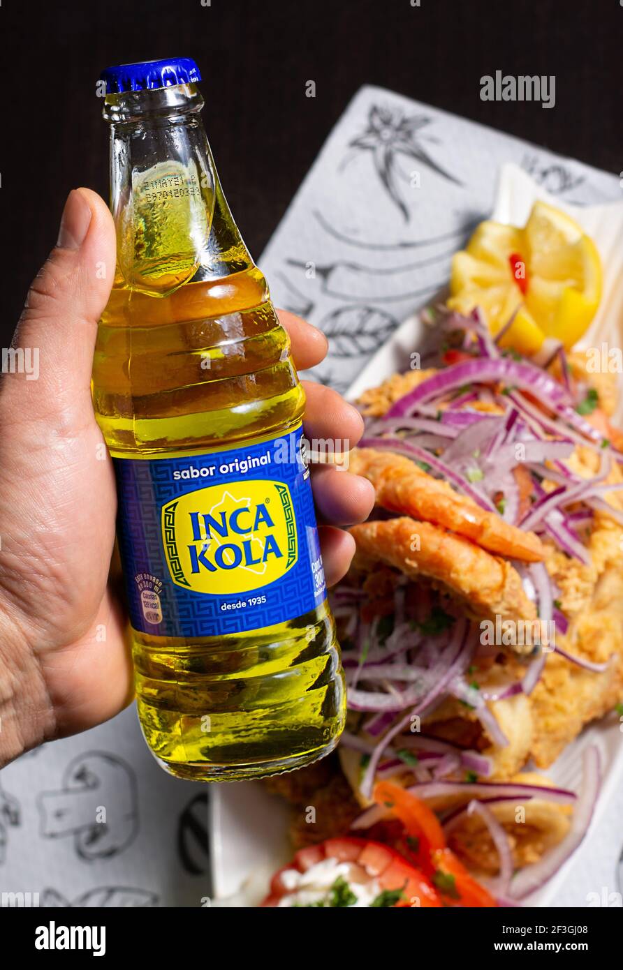 Cusco, Peru, 28,02.2021. Inka Kola, peruanisches Softdrink und gebratenes Fischgericht Stockfoto