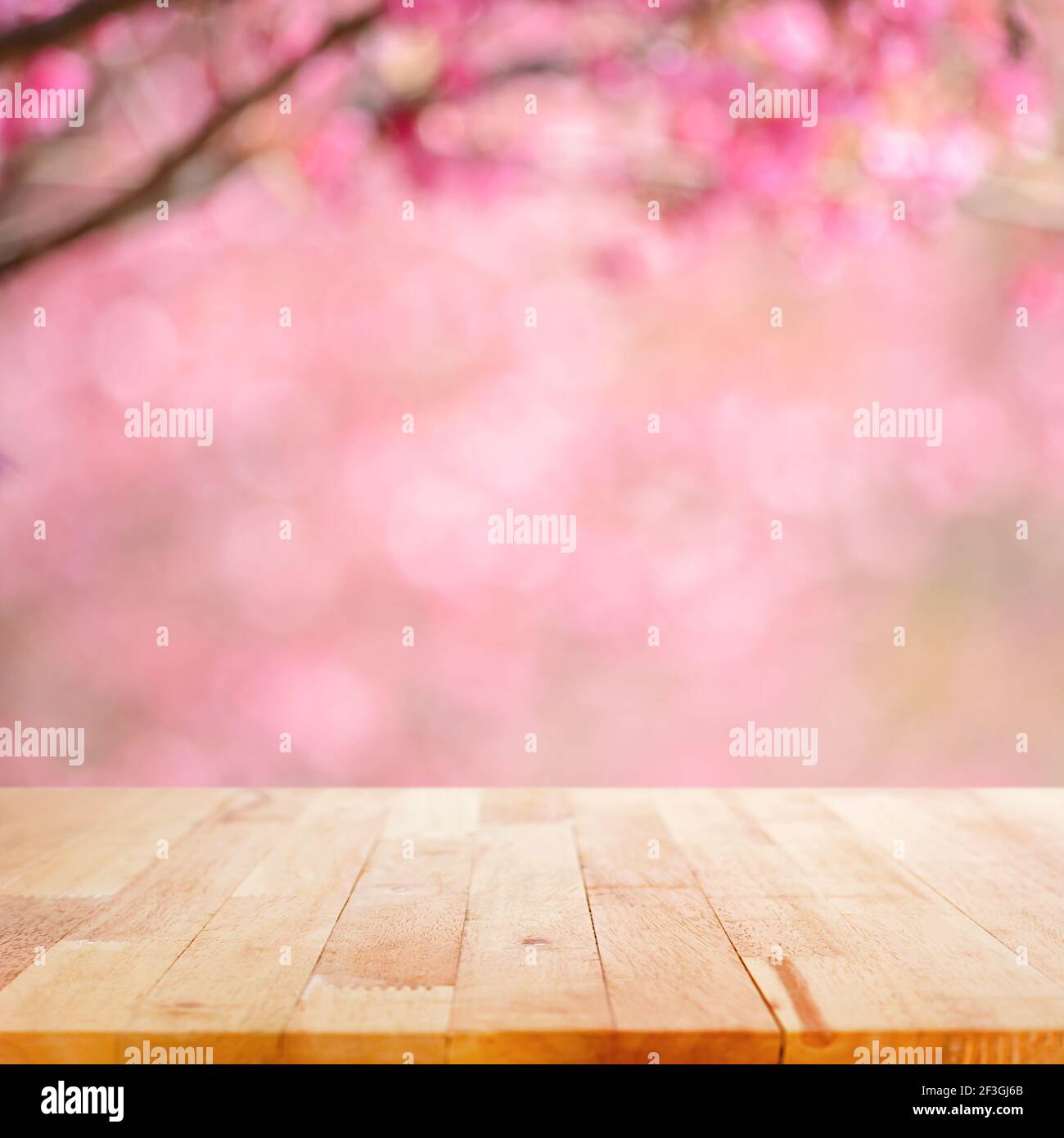 Holztischplatte auf verschwommenem Hintergrund von rosa Kirschblüte Blume - kann für die Anzeige oder Montage Ihrer Produkte verwendet Stockfoto
