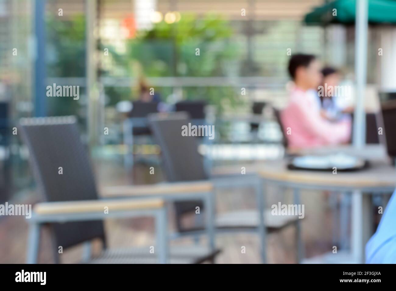 Verschwommener Hintergrund eines Cafés im Freien mit Sitzenden Stockfoto