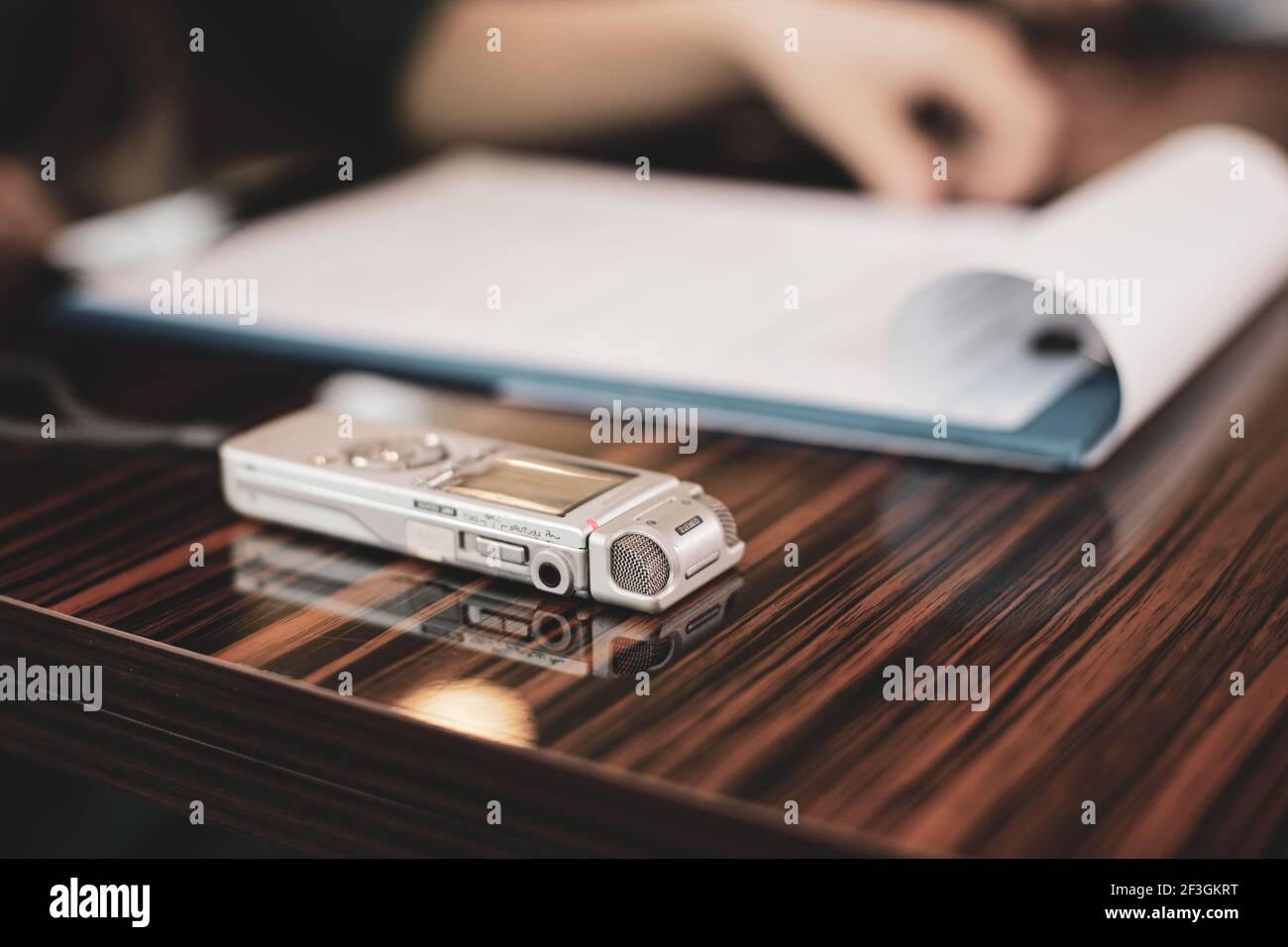 Bild mit geringer Schärfentiefe (selektiver Fokus) mit einem Audiorecorder einer Journalistin während eines Interviews. Stockfoto