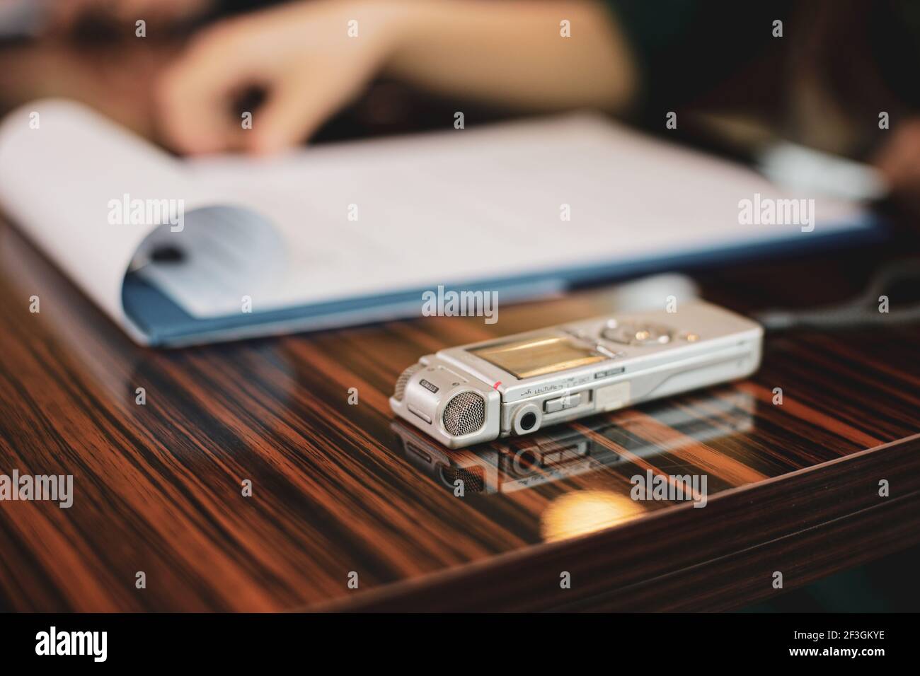 Bild mit geringer Schärfentiefe (selektiver Fokus) mit einem Audiorecorder einer Journalistin während eines Interviews. Stockfoto