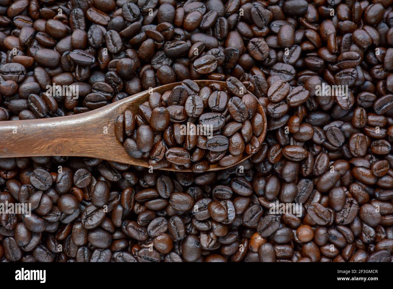 Löffel Kaffeebohnen auf Kaffeebohnenhaufen Stockfoto