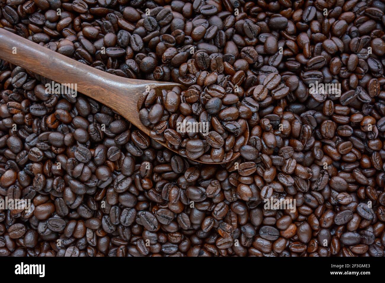 Löffel Kaffeebohnen auf Kaffeebohnenhaufen Stockfoto
