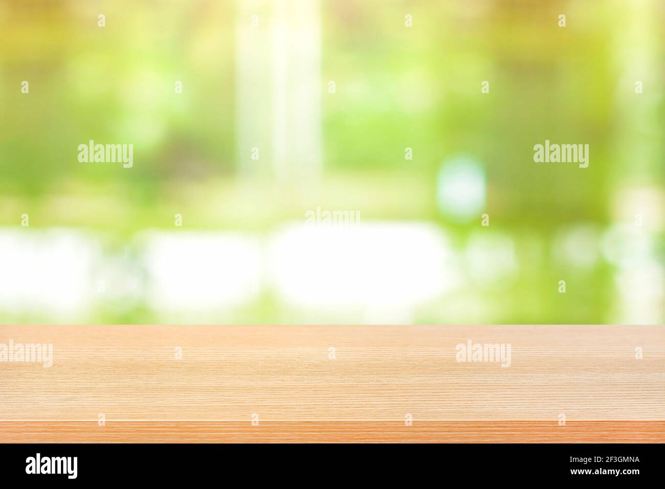 Holztischplatte auf verschwommenem grünen Hintergrund - kann sein Wird zur Montage oder Anzeige Ihrer Produkte verwendet Stockfoto