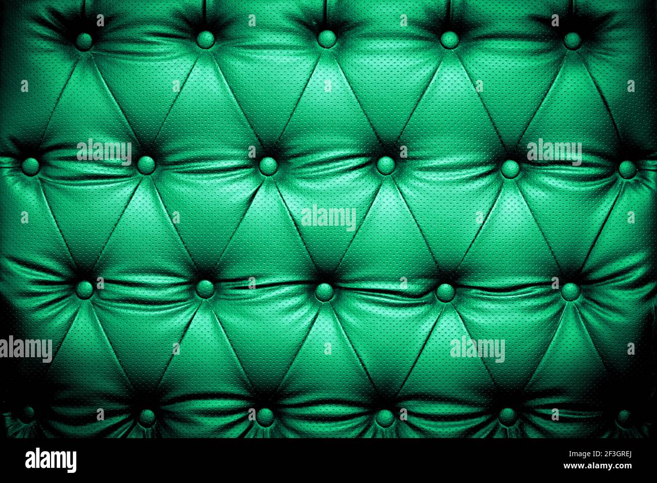 Hintergrund mit grüner Lederstruktur und knöpfbarem Muster Stockfoto