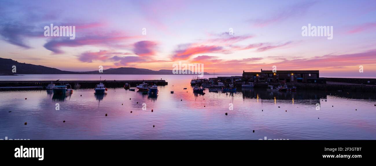 Lyme Regis, Dorset, Großbritannien. März 2021, 17th. UK Wetter: Spektakuläre Sonnenaufgangsfarbe über dem Cobb bei Lyme Regis zu Beginn eines schönen Frühlingstages. Kredit: Celia McMahon/Alamy Live Nachrichten Stockfoto