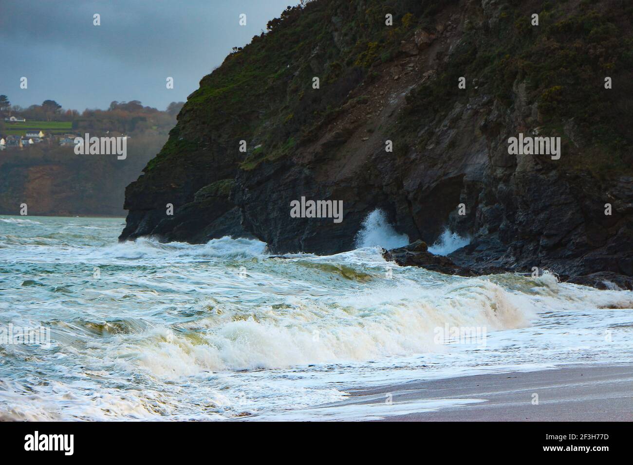Atlantische Sturmwellen krachen auf und wuschen über Felsen und Sand am Carlyon Bay Beach in Cornwall am südwestküste von England Stockfoto