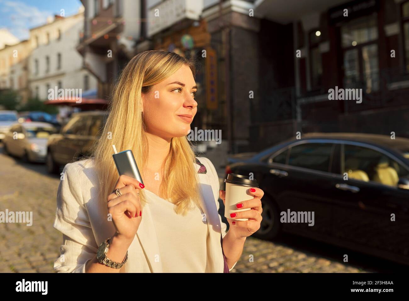 System der Heizung Tabak, Papiertasse Kaffee in den Händen der Frau auf der Straße der Stadt Stockfoto