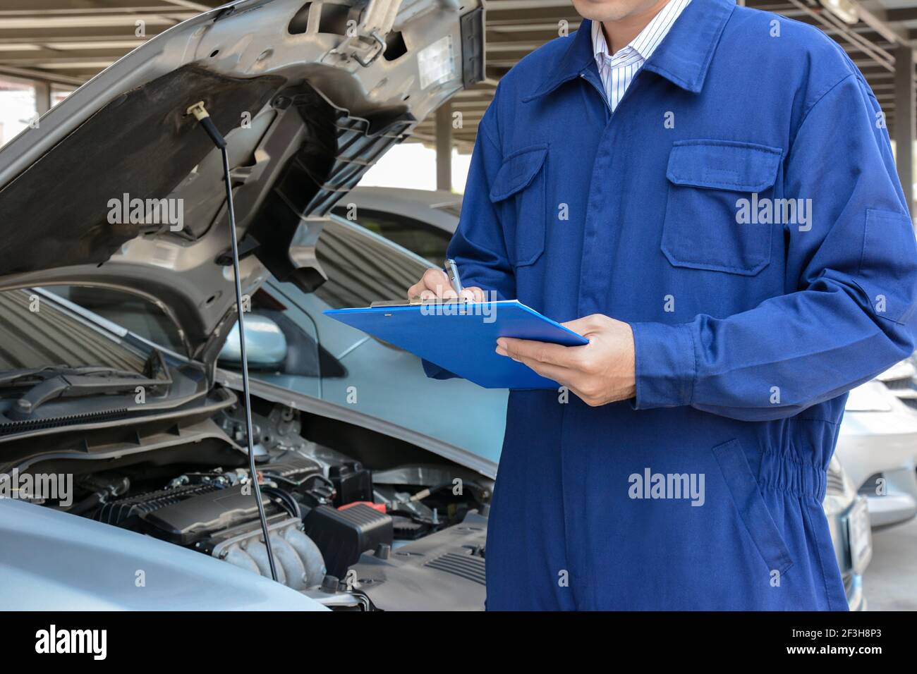 Automechaniker (oder Techniker), der den Automotor in der Garage überprüft Stockfoto