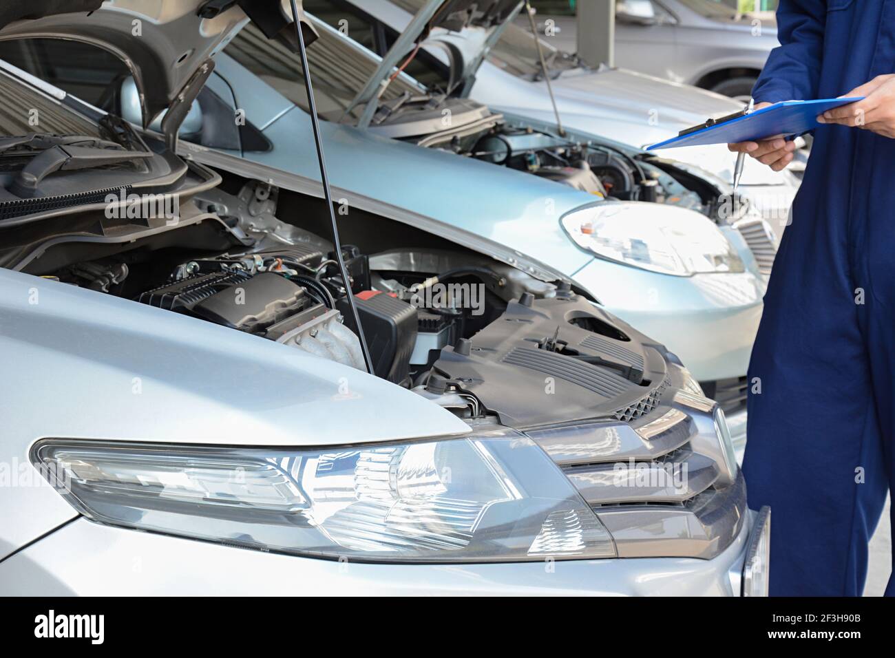 Automechaniker (oder Techniker), der den Automotor in der Garage überprüft Stockfoto