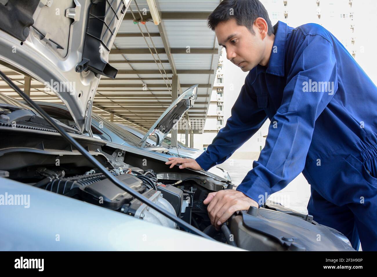 Automechaniker (oder Techniker), der den Automotor überprüft Stockfoto