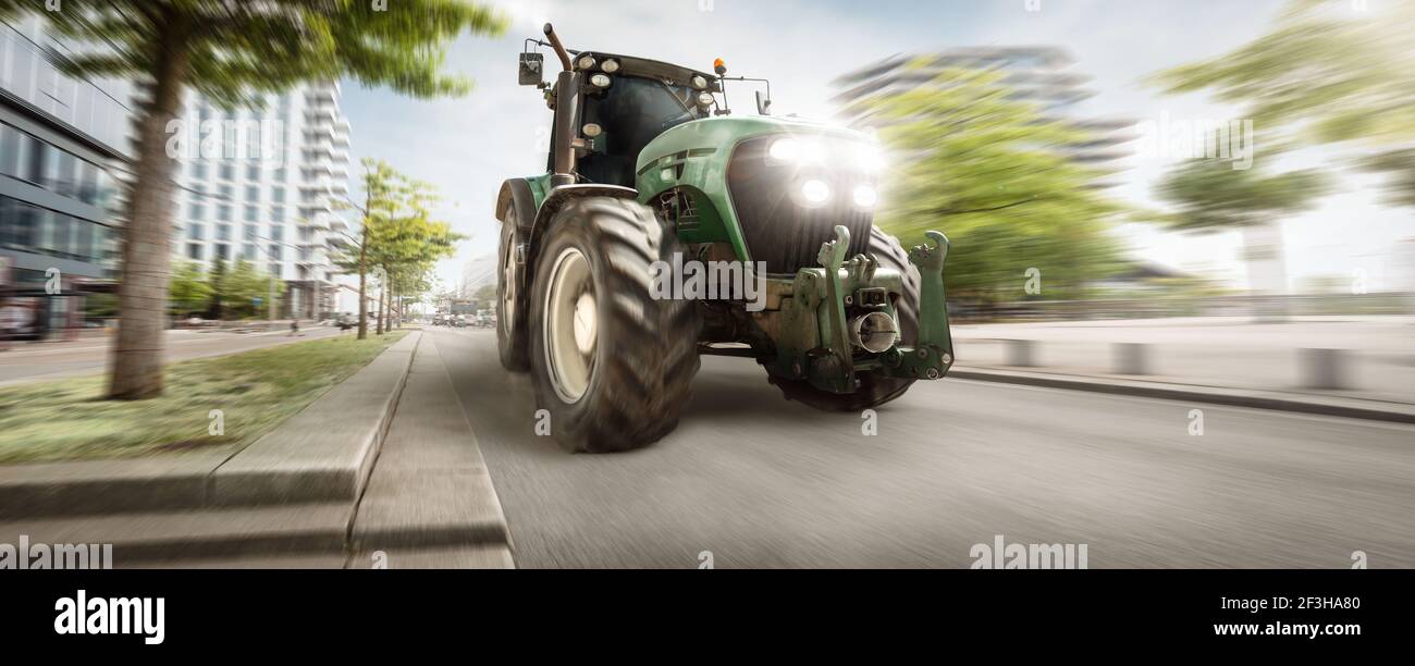 Traktor fährt durch eine Stadt Stockfoto