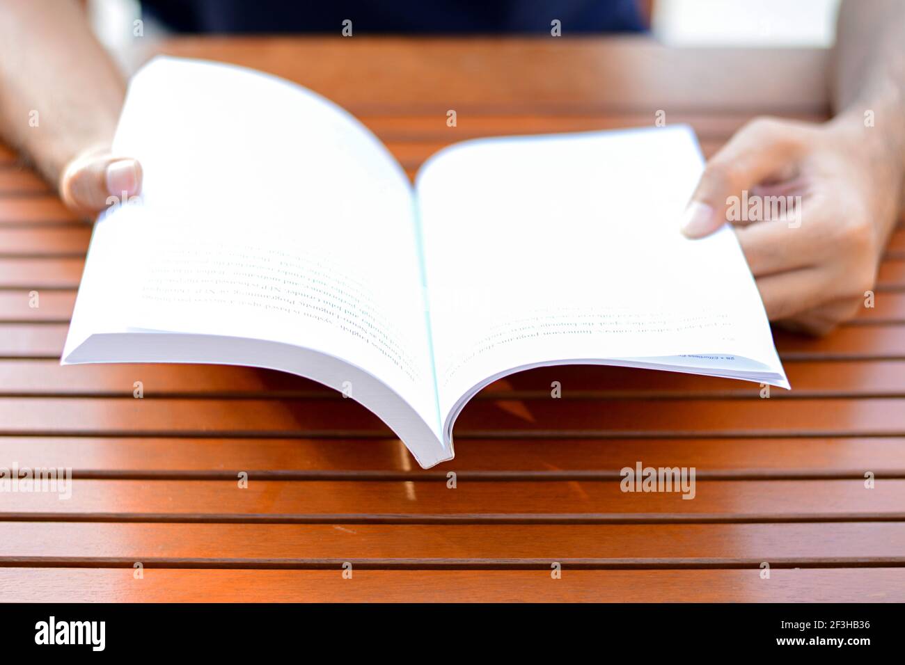 Hände öffnen Buch auf dem Tisch - Lesekonzept Stockfoto