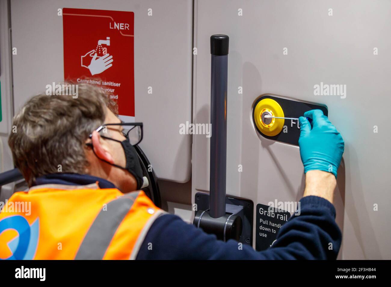 REDAKTIONELLE VERWENDUNG NUR EIN Reiniger strichen einen Knopf an Bord eines Zugwagens während der Nacht, da ein Team von 360 Spezialisten rund um die Uhr arbeitet, um die verbesserte Reinigungszusage der London North Eastern Railway (LNER) "Covid Secure" zu liefern, um Kunden zu halten, die während der Pandemie notwendige Fahrten sicher machen müssen. Ausgabedatum: Mittwoch, 17. März 2021. Stockfoto