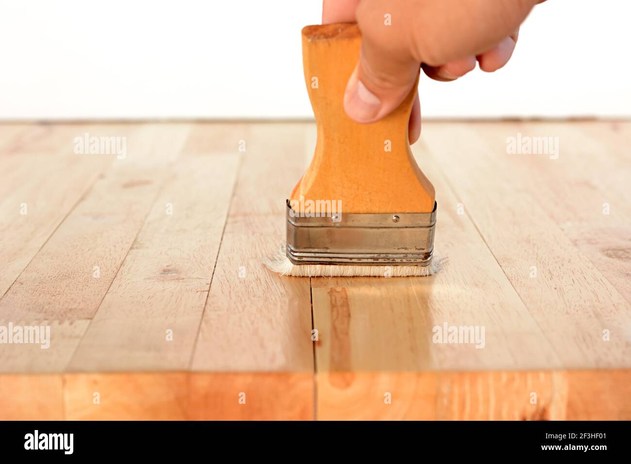 Hand mit Pinsel auf Holz Tischplatte Stockfoto