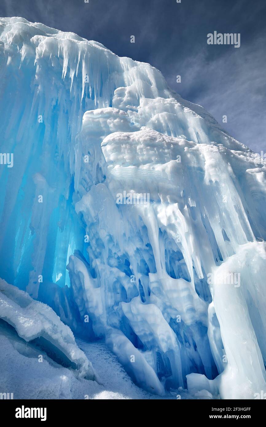 Gefrorener Bergwasserfall mit Eiszapfen gegen blauen Himmel in Almaty, Kasachstan Stockfoto