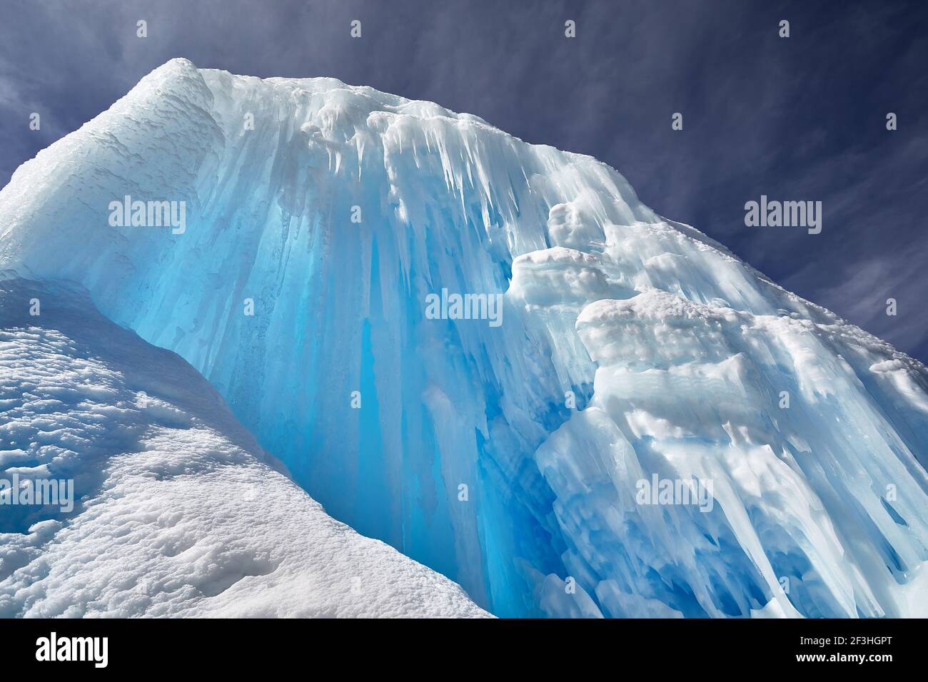 Gefrorener Bergwasserfall mit Eiszapfen gegen blauen Himmel in Almaty, Kasachstan Stockfoto