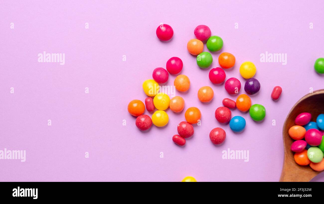 Mehrfarbiges Bonbon-Set mit einem Holzlöffel Stockfoto