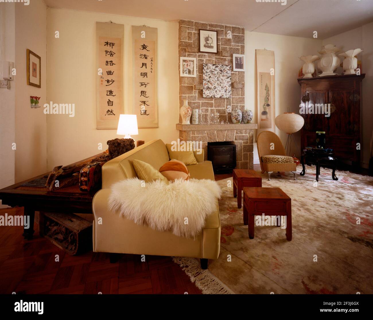 Wohnzimmer einer modernen chinesischen Wohnung mit einer Mischung aus kulturellen Stilen Hongkong, China. Ein 1940s Stuhl ist mit Leopardenfell bedruckt fabri bedeckt Stockfoto